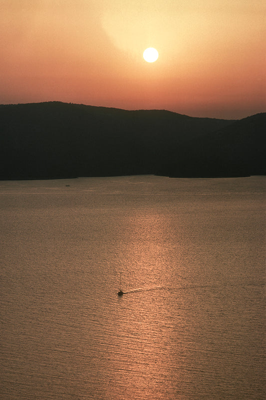 Sunset, the small boat returns to Ithaca