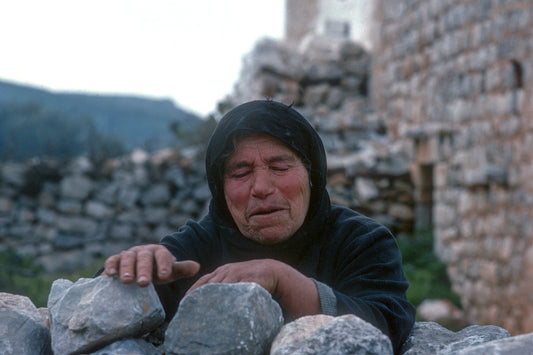 A woman from Mani is resting on the pen wall