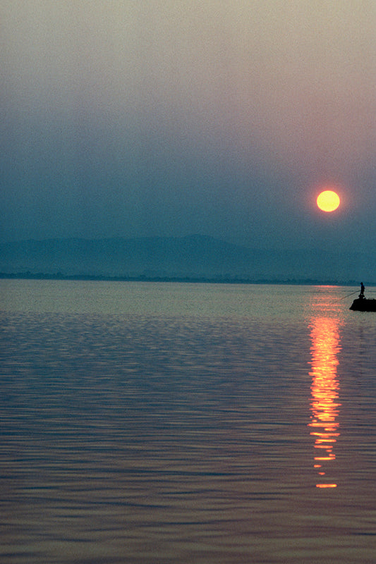 Sunset in the Ionian Sea and a fisherman in the vackground